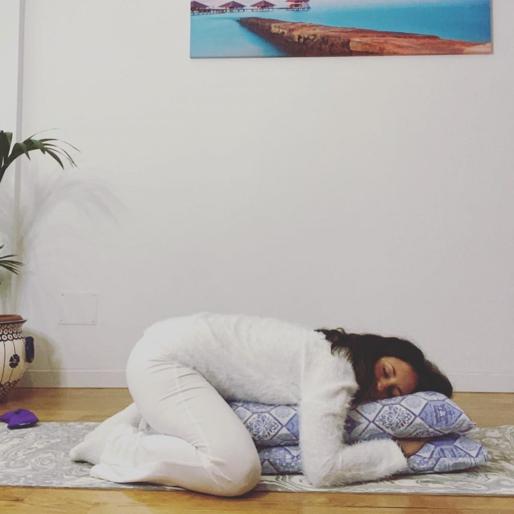 Giorgia Colavolpe in una posizione di restorative yoga appoggiata a cuscini